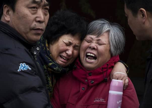 Chinese relatives weep outside the Lama Temple in Beijing. Picture: Getty