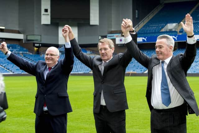 John Gilligan, Dave King and Paul Murray raise their arms in triumph on the Ibrox pitch. Picture: SNS
