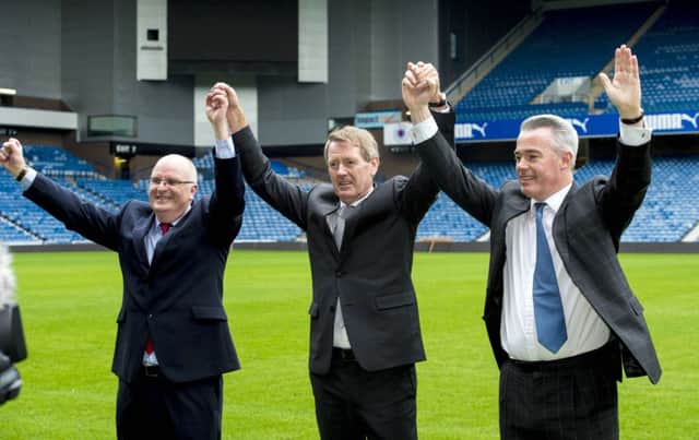John Gilligan, Dave King and Paul Murray raise their arms in triumph on the Ibrox pitch. Picture: SNS
