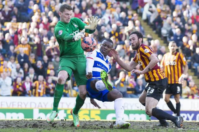 Reading's Yakubu, centre, fights for the ball against Bradford goalkeeper Ben Williams. Picture: AP