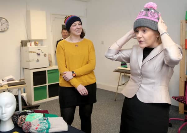 First Minister Nicola Sturgeon tries on a woolly hat as she talks to Wonky Woolies Founder Alison Burn in Glasgow. Picture: PA