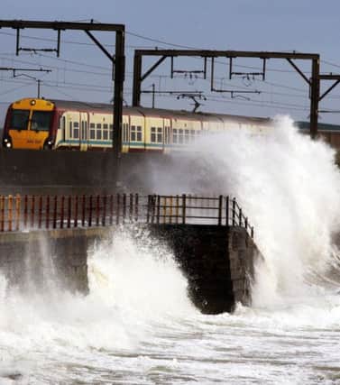 A train goes past the seafront  in the coastal town of  Saltcoats. Picture: PA