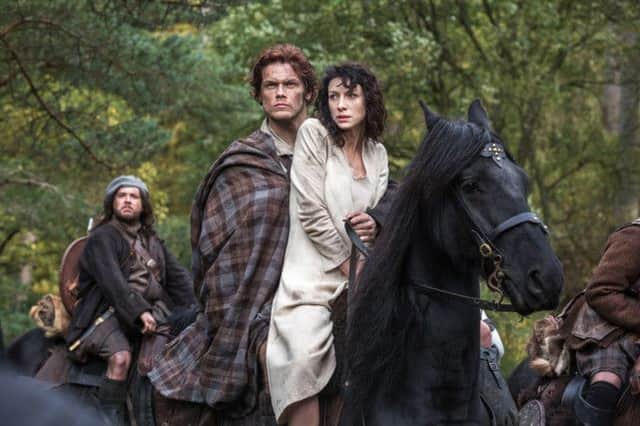 Caitriona Balfe as Claire Randall, right, and Sam Heughan as Jamie Fraser, centre, in a scene from Outlander. Picture: AP