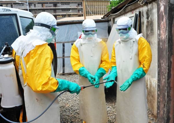 Medical staff clean their protection suits. Pic: Getty Images