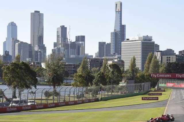 Melbourne's skyline provides the backdrop as Ferrari's Sebastian Vettel drives. Picture: AP