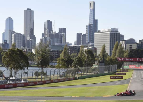 Melbourne's skyline provides the backdrop as Ferrari's Sebastian Vettel drives. Picture: AP
