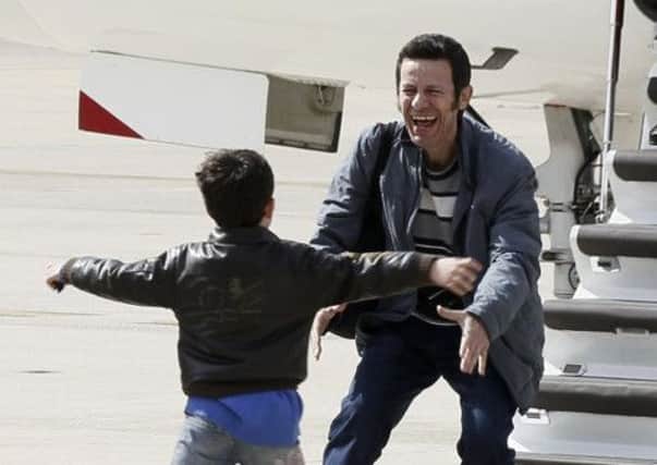 Javier Espinosa  shows his delight at being reunited with his son at a military airbase. Picture: Getty