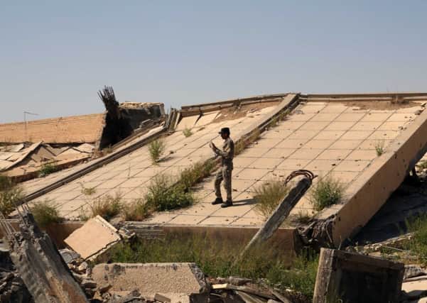 An Iraqi soldier takes photos of the demolished tomb of former Iraqi president, Saddam Hussein, in Tikrit. Picture: AP