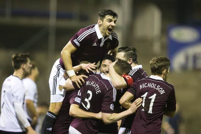 Hearts players mob Kevin McHattie after the defender opened the scoring. Picture: SNS
