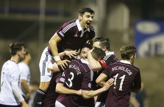 Hearts players mob Kevin McHattie after the defender opened the scoring. Picture: SNS