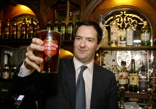 Chancellor George Osborne holding a pint of beer. Duty was cut on certain types of alcohol. Picture: PA