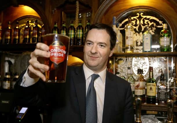 Chancellor George Osborne holding a pint of beer. Duty was cut on certain types of alcohol. Picture: PA