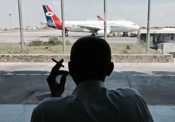 A passenger stranded by the gun battle waits at the airport. Picture: AP