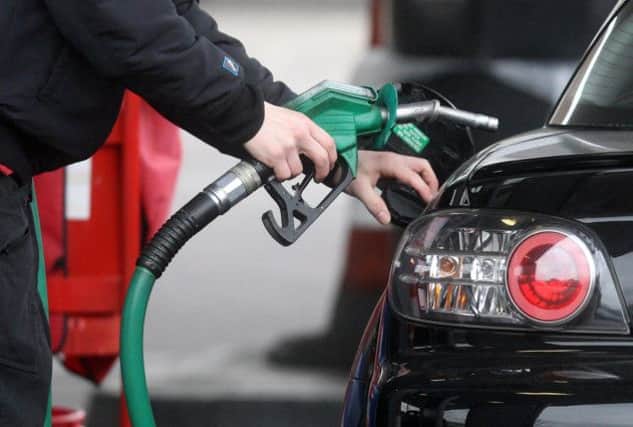 A driver refuelling at a petrol station (diesel, fuel)