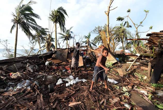 A young boy and his father outside the ruins of their family home in Vanuatu's capital Port Villa. Picture: Getty