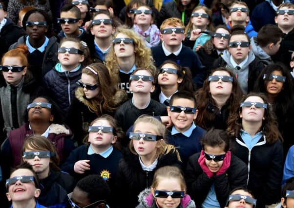 School children view the eclipse correctly using special protective glasses in Glasgow. Picture: Getty