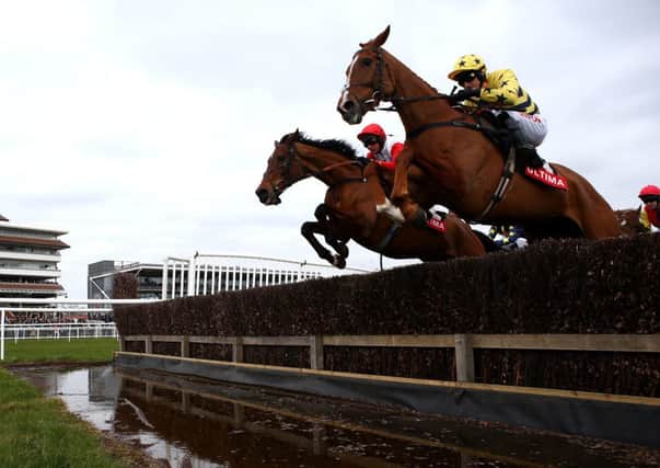 Jockey Nico de Boinville, left, clears the water jump on Carruthers. Picture: Getty