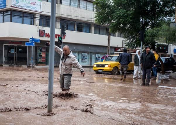 A man wades across one of the flooded streets in the city of Copiapo. Picture: AFP/Getty