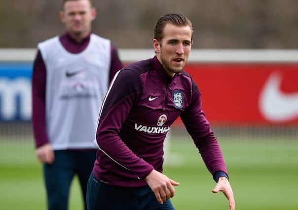 Harry Kane is put through his paces yesterday as England captain Wayne Rooney looks on. Picture: Getty