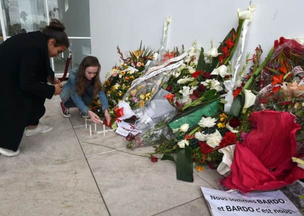 People light candles at the national Bardo Museum in Tunis in memory of the victims. Picture: AFP/Getty