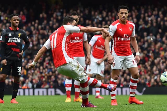 Arsenals German midfielder Mesut Ozil fires in a free-kick to score their second goal against Liverpool. Picture: Getty Images