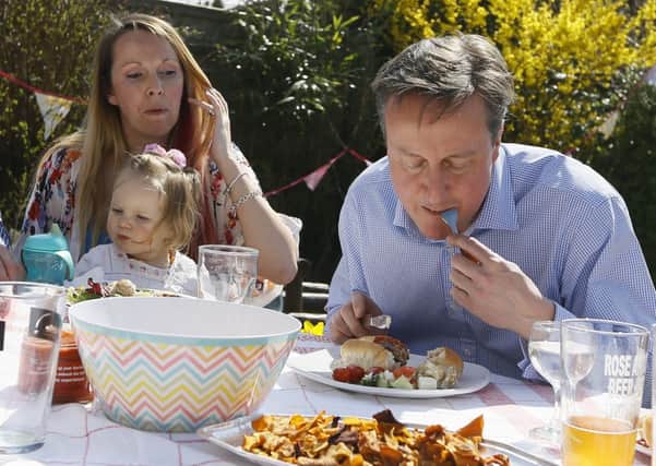Cameron eats lunch in garden with people who have benefited from tax and pension changes. Picture: AP
