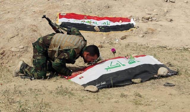 A Shiite militiaman pays tribute at the site of the massacre. Picture: AP