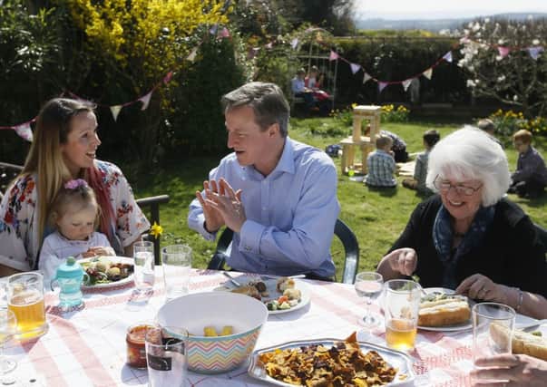 Prime Minister David Cameron speaks with Jo White, and Lilli Docherty with her daughter Dakota, as he has lunch with people who have benefited from tax and pension changes in Poole, England. Picture: Getty