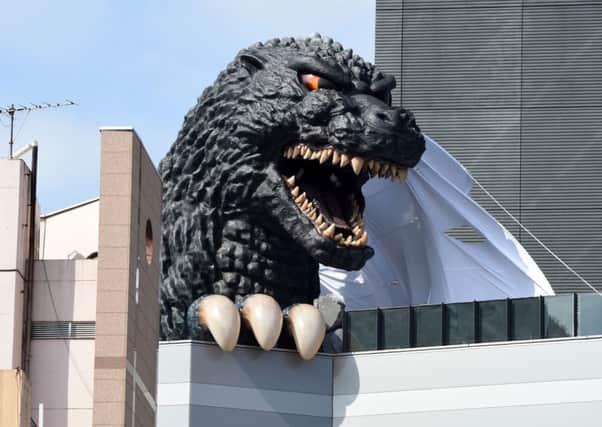A life-size Godzilla head appears on a balcony of the eighth floor of Hotel Gracery Shinjuku in Tokyo. Picture: AFP/Getty