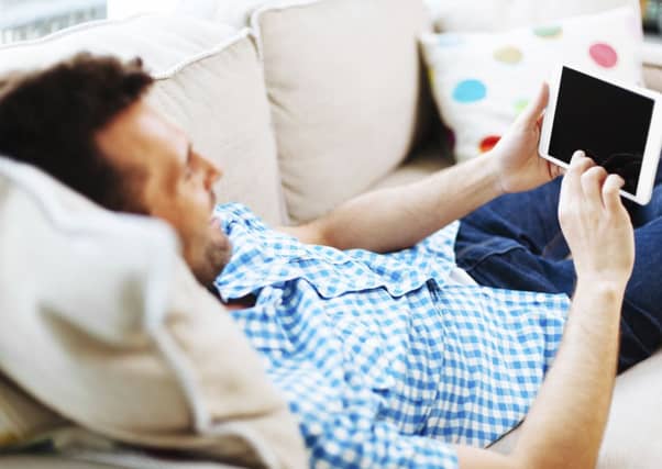 Relaxing with a tablet or smartphone puts far more pressure on the discs in the back than walking around, meaning under-30 devotees are suffering. Picture: Getty