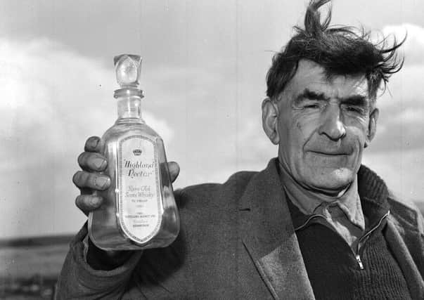South Uist man John Morrison with an empty bottle of Highland Nectar whisky he liberated from the SS Politician when she ran aground in 1941. Picture: TSPL