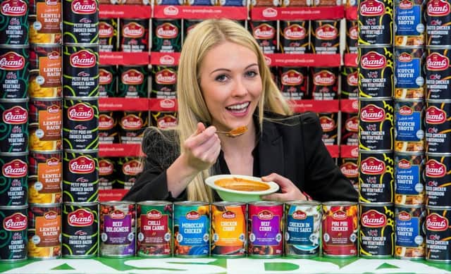 Claire Inglis with some of the cans in Grants range, including Piri Piri Chicken and Moroccan Chicken