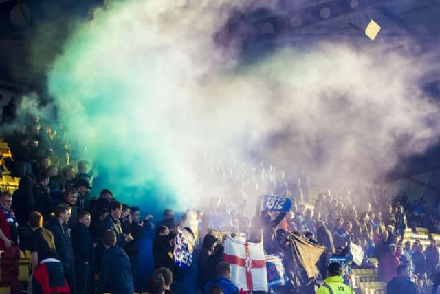 A flare is set off among Rangers fans at last night's game at Almondvale Stadium. Picture: SNS