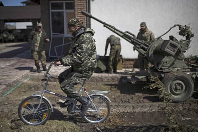 A Ukrainian serviceman rides a bicycle on a street in Shyrokyne, eastern Ukraine. Picture: AP