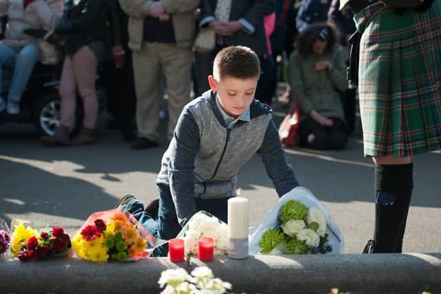A boy leaves flowers for murdered student Karen Buckley. Picture: John Devlin