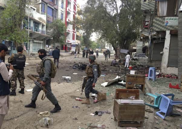 Afghan security forces members inspect the site of the suicide attack near a new Kabul Bank in Jalalabad, east of Kabul. Picture: AP
