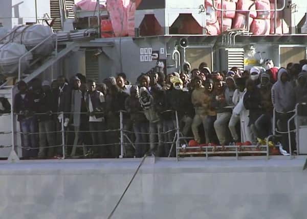 Migrants aboard an Italian navy vessel as it cruises towards the port of Messina. Picture: AP