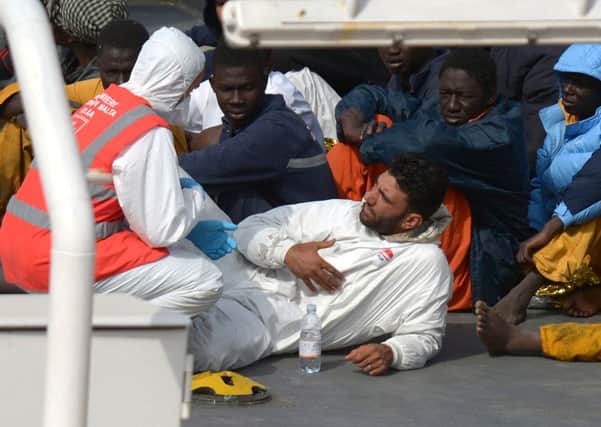 Rescued migrants talk to a member of the Malta Order after a fishing boat carrying migrants capsized. Picture: Getty