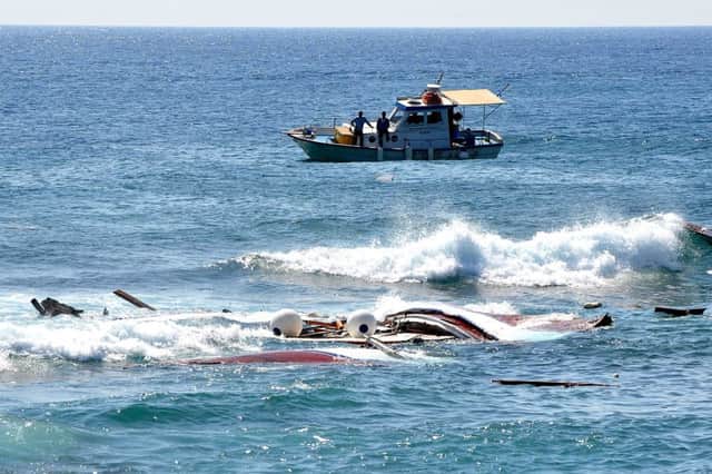 Fishermen approach the wreckage of a boat which was carrying migrants off the island of Rhodes, Greece. Picture: AP