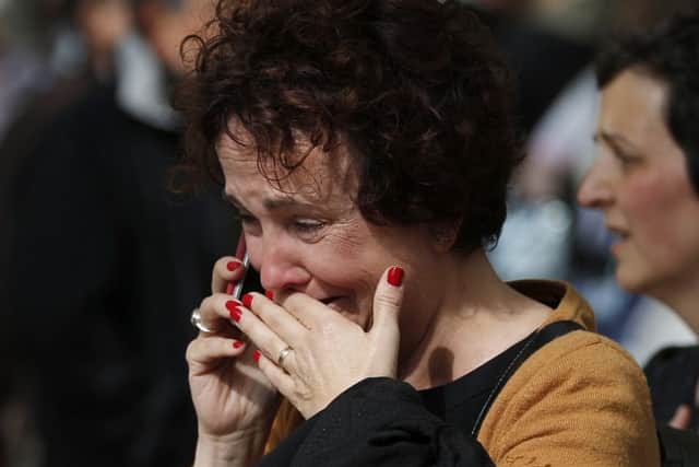 A distraught woman talks on a phone outside the high school. Picture: AP