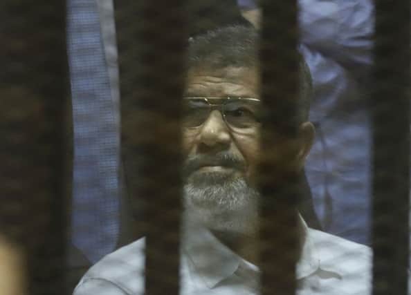 Ousted Egyptian president Mohammed Morsi sits in a soundproof glass cage. Picture: Getty
