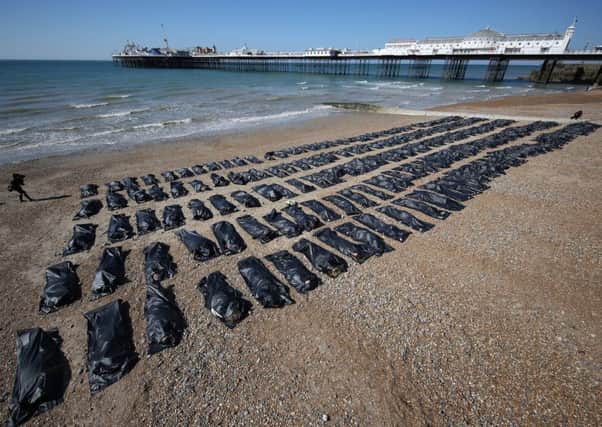 Amnesty International volunteers in body bags on Brighton beach highlight the Med migrant crisis. Picture: Getty