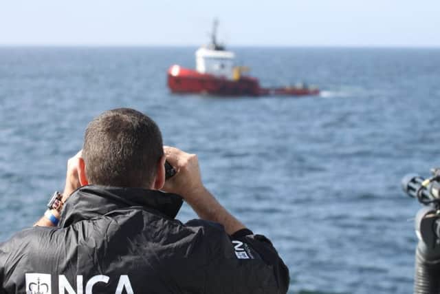 The ocean-going tug MV Hamal is watched by an NCA officer. Picture: NCA/PA
