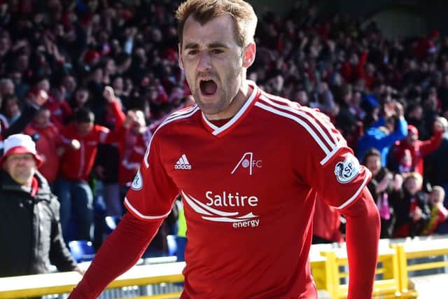 Aberdeen's Niall McGinn wheels away in celebration having hammered the ball home to put his side ahead. Picture: SNS