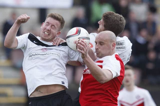 Brora Rangers Grant Munro, in the red shirt, wins an aerial tussle with Shaun Harrison. Picture: Toby Williams