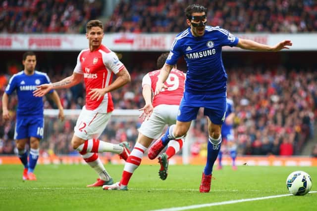 Cesc Fabregas, wearing a special protective face mask, is challenged by Santi Cazorla. Picture: Getty