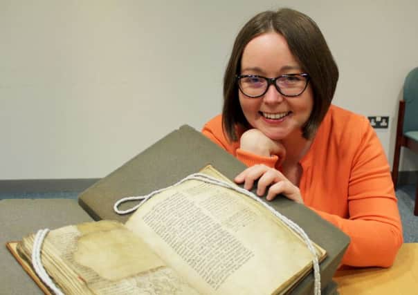 Dr Kylie Murray with the manuscript, the oldest surviving non-biblical manuscript in Scotland. Picture: Hemedia