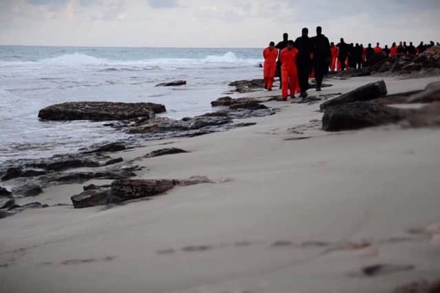 Islamic State (IS) group fighters lead handcuffed Egyptian Coptic Christians before their  decapitation on a seashore in the Libyan capital of Tripoli.