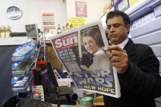 A man reads the Scottish Sun in an Edinburgh shop on the day the paper backed the SNP. Picture: PA