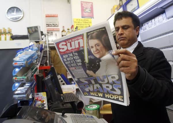 A man reads the Scottish Sun in an Edinburgh shop on the day the paper backed the SNP. Picture: PA